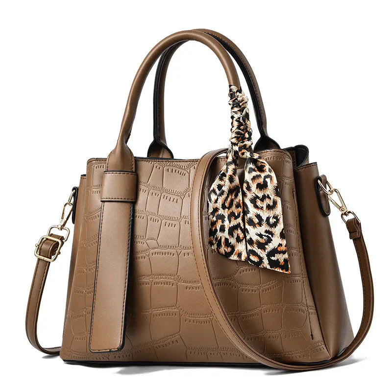 Structured women's black embossed leather tote bag with elegant texture and versatile top handles