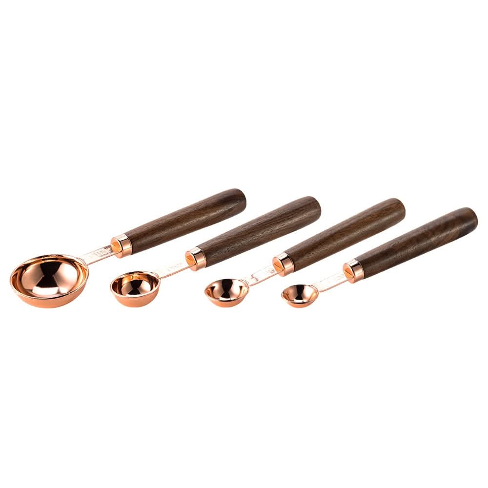 Gold-toned metal measuring cup set with wood handles, engraved markings, elegant kitchen tool