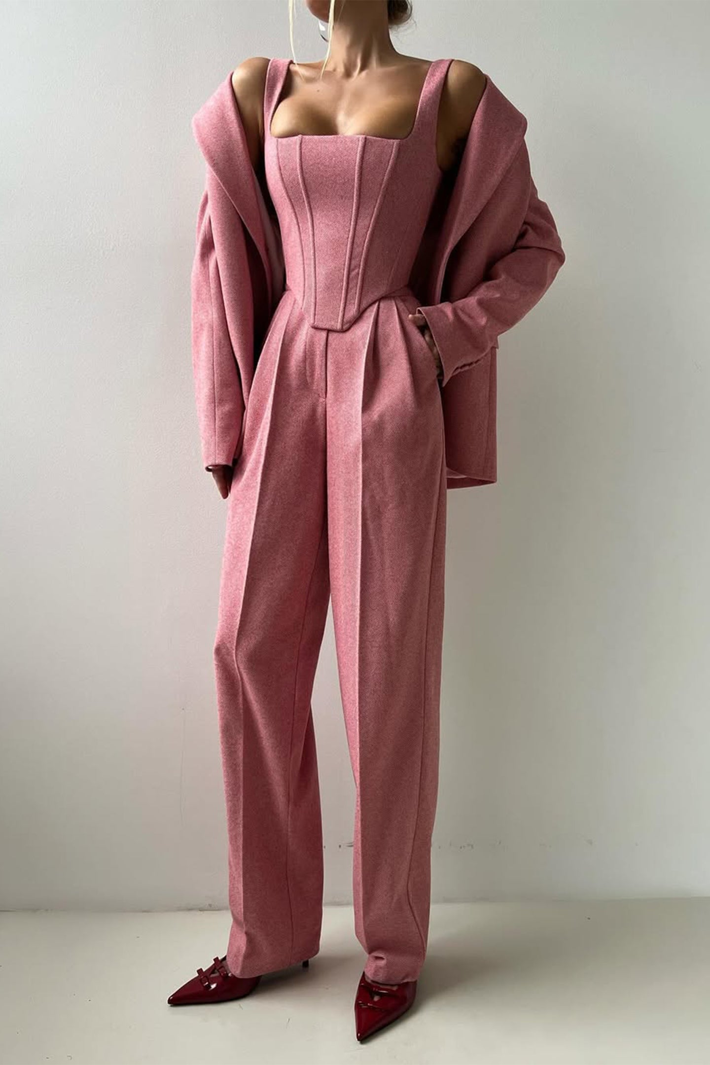 Ivory three-piece tailored suit set with structured blazer, bustier top, and wide-leg trousers