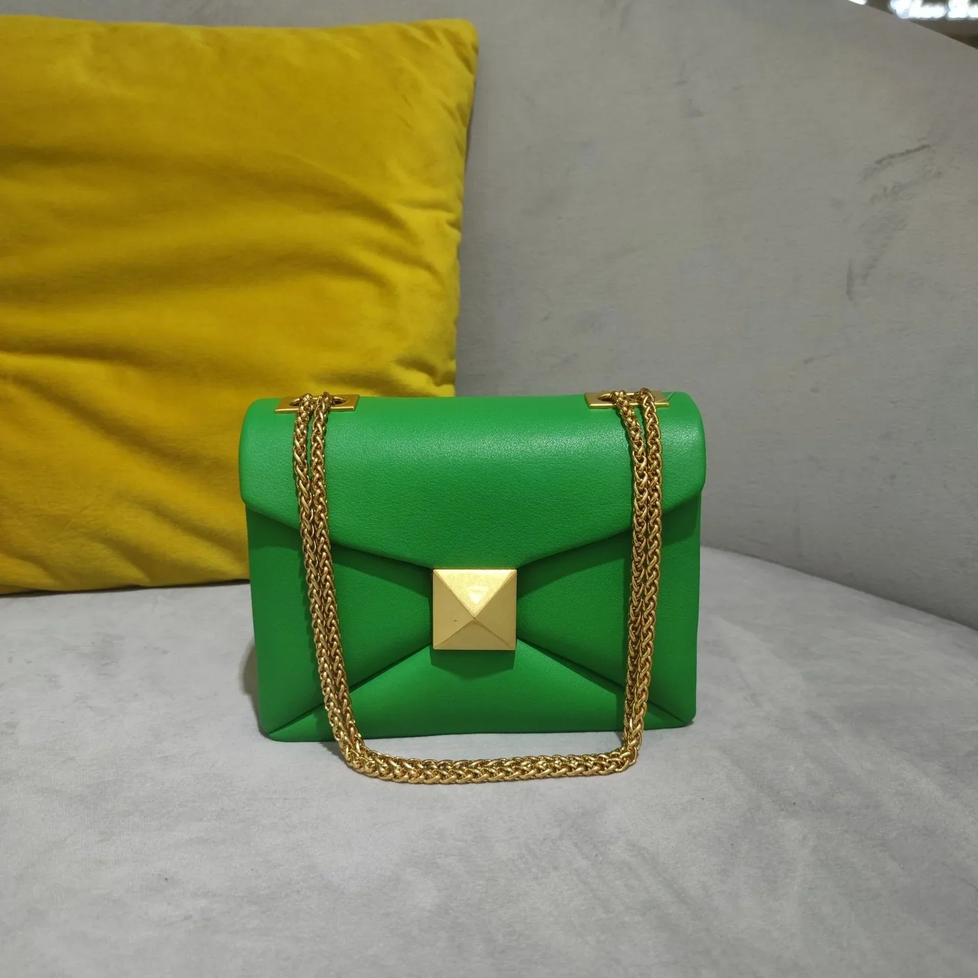 Women's faux leather envelope crossbody bag with rivet hardware detailing and gold chain strap