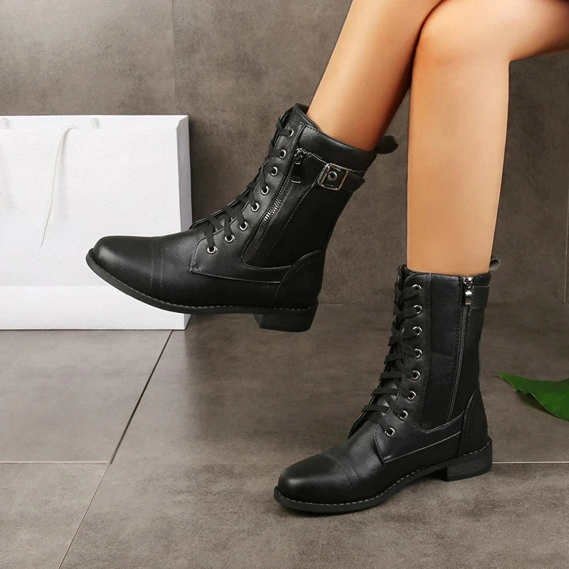 Women's black synthetic leather mid-calf moto boot with bold buckle accents and lace-zip closure