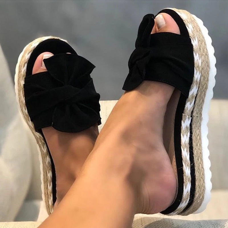 Women's vibrant yellow platform slides with braided sole and oversized bow, bold summer style