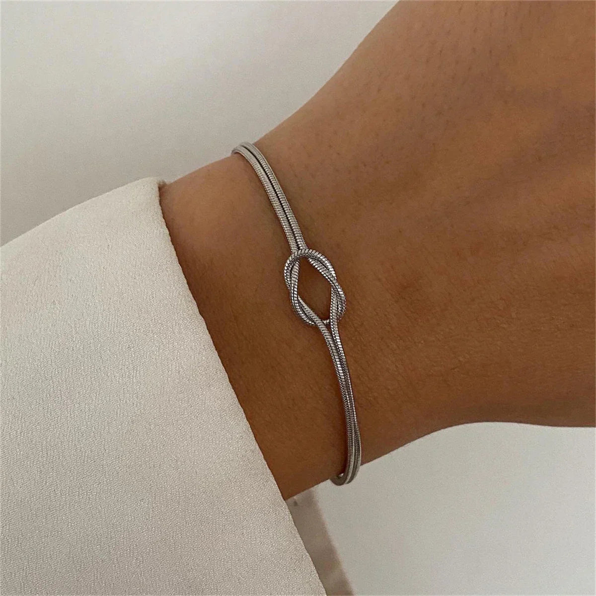 Gold-plated stainless steel link bracelet with delicate knot centerpiece, tarnish-resistant, everyday elegance