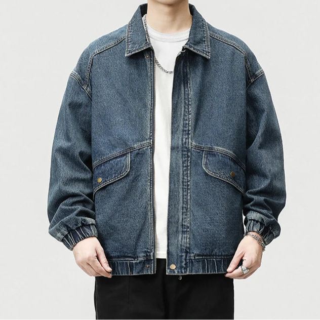 Medium wash oversized boxy denim jacket with draped sleeves and retro streetwear style