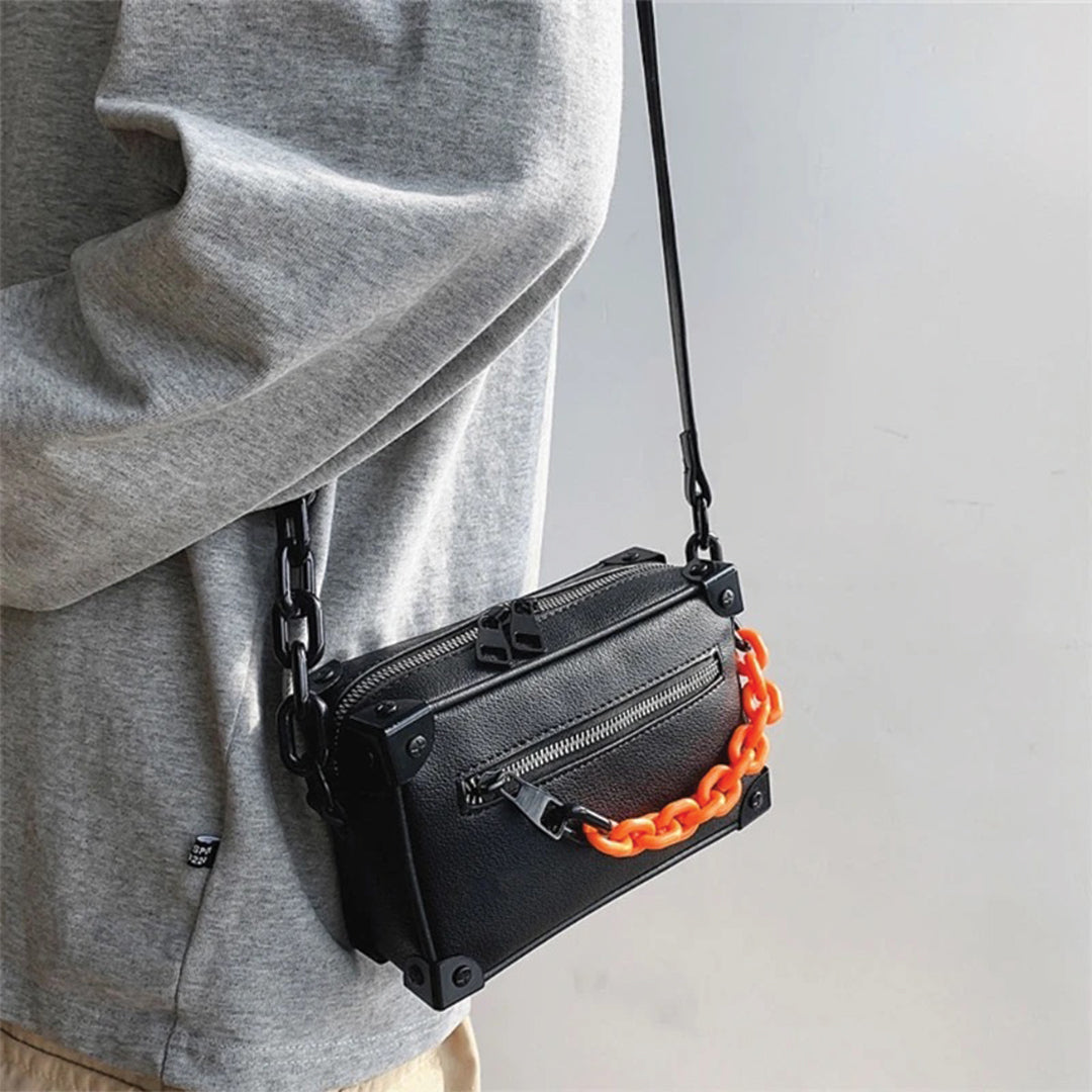 Black square crossbody satchel with detachable chain strap and polished envelope closure for city professionals