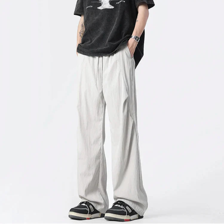 Neutral tufted parachute pants wide-leg crinkled nylon lightweight breathable streetwear urban style