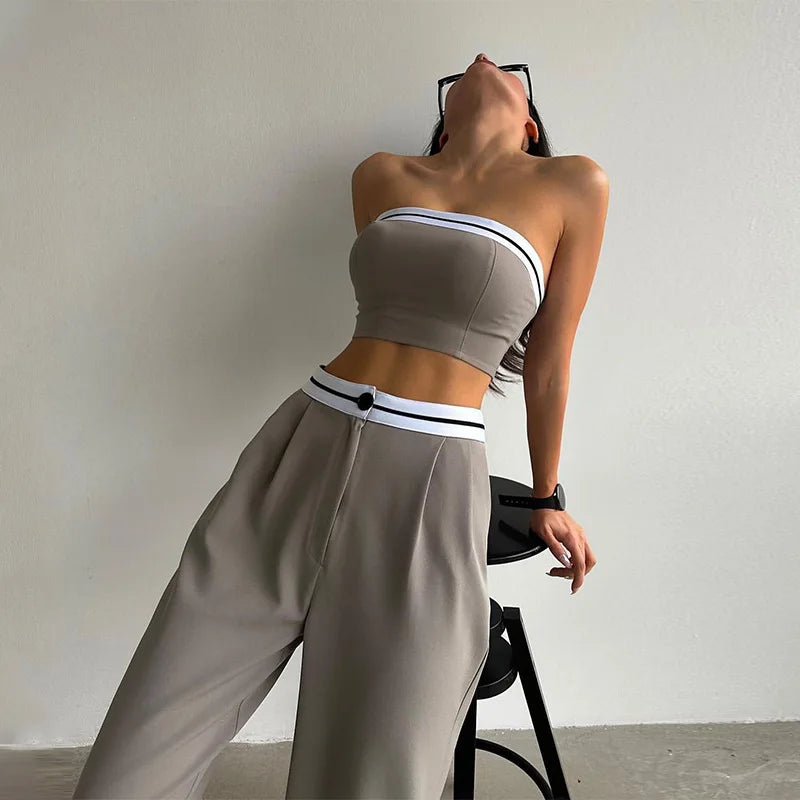 Ivory two-piece set with sculpted bandeau top and draped wide-leg pants, sleek modern silhouette