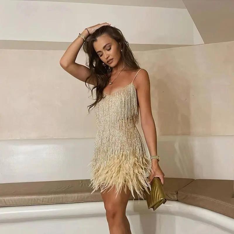 Women's silver sequined mini dress with glamorous feather-trimmed hem for evening parties