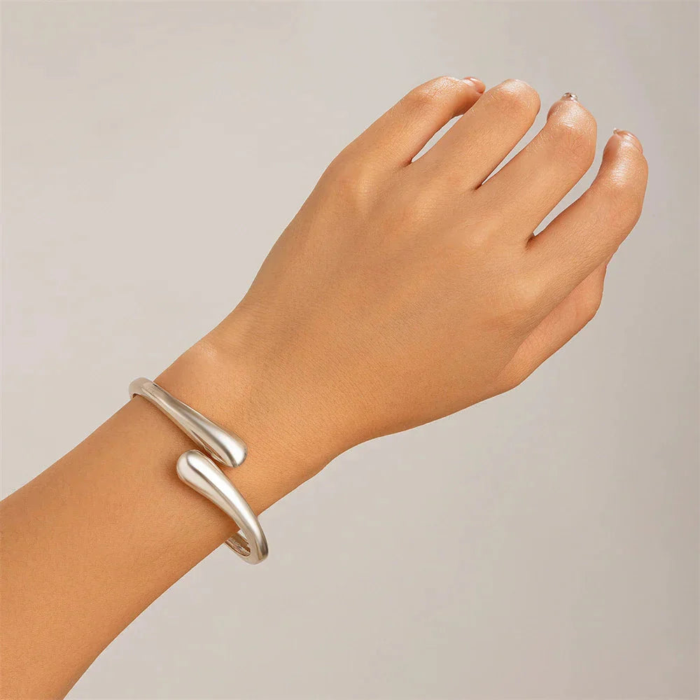 Women's sculptural open cuff bracelet and wraparound ring set, elegant minimalist gold-tone duo
