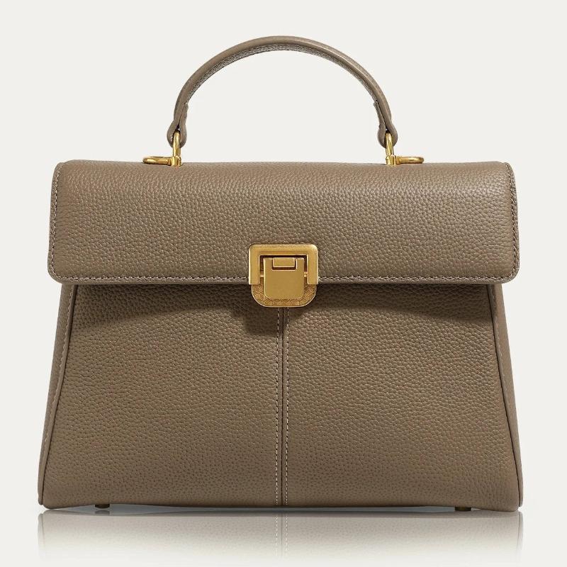 Women's structured top handle leather handbag in classic silhouette with secure flap closure for work travel