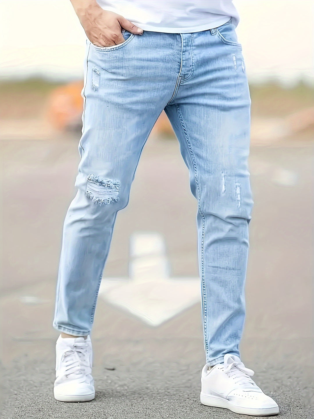 Men's slim fit stretch denim jeans with ripped detailing, tapered ankle cut for edgy streetwear style