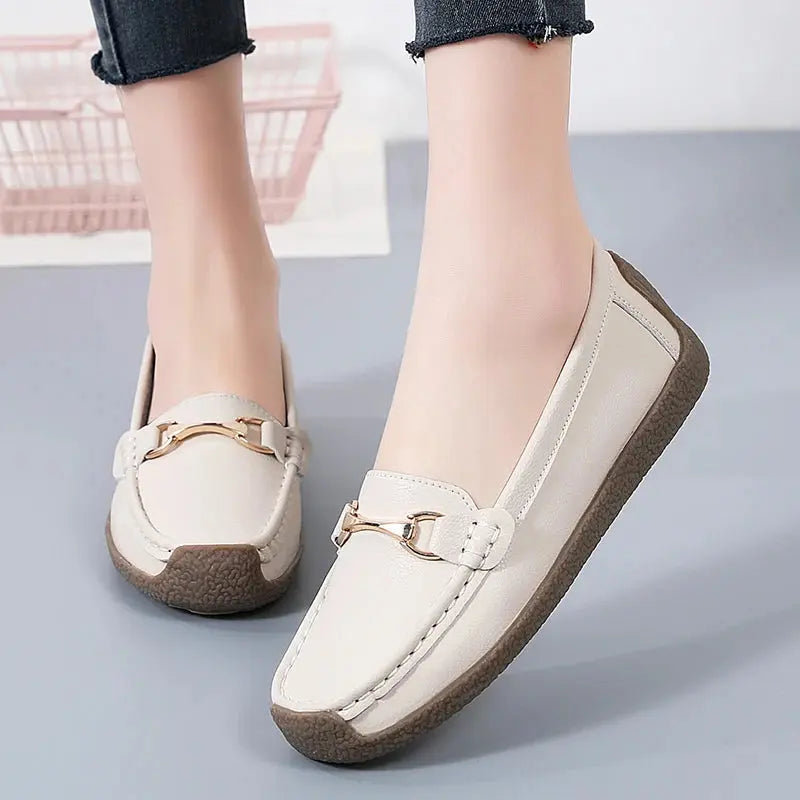 Women's slip-on moccasin flats in neutral tone with soft faux leather upper and flexible sole