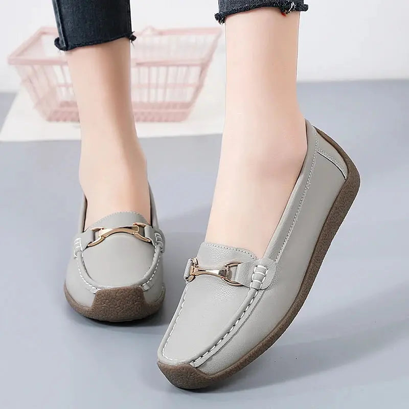 Women's slip-on moccasin flats in neutral tones with soft faux leather upper and flexible sole