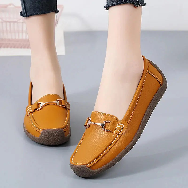 Women's slip-on moccasin flats in neutral tone with soft faux leather upper and flexible sole