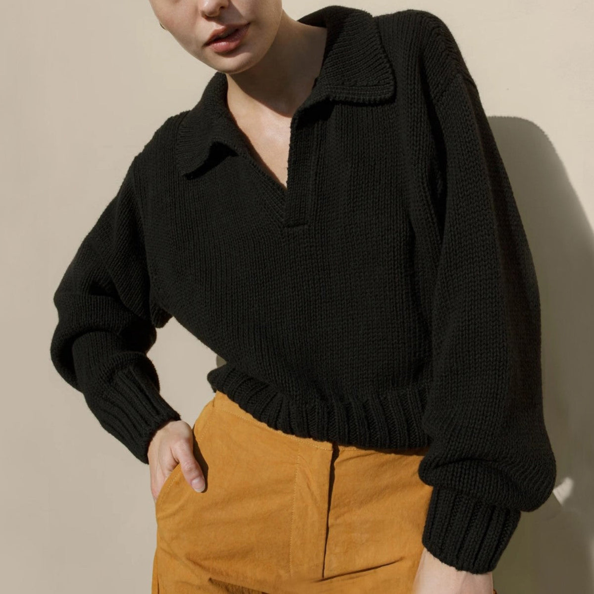 Women's loose fit knit sweater in neutral tones with bold lapel and irregular design detail