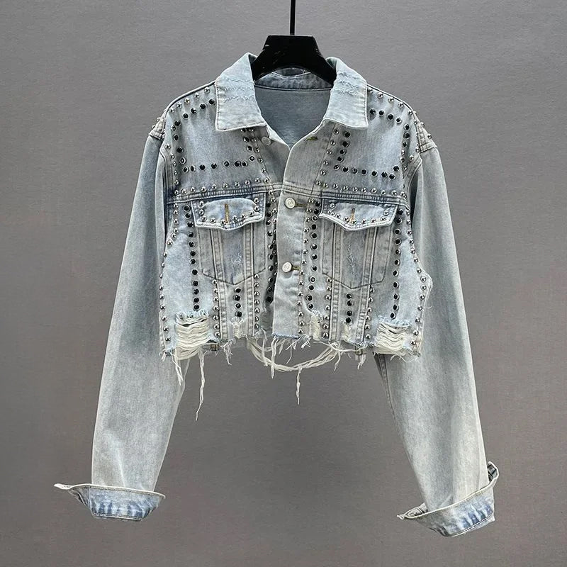 Cropped blue denim jacket with metallic studs embellishment, structured waist-defining street style cut