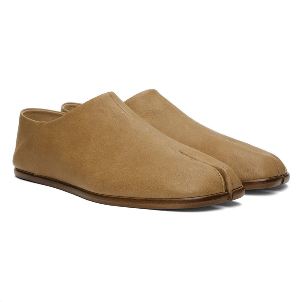 Black leather tabi loafers with split-toe silhouette, heritage craftsmanship meets modern urban edge