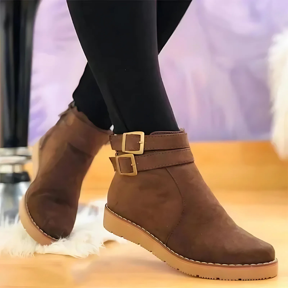 Women's black structured ankle boots with double buckle straps, thick textured soles, edgy chic style