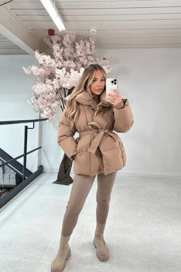 Women's belted puffer jacket with high collar, plush padding, flattering silhouette, cozy winter warmth