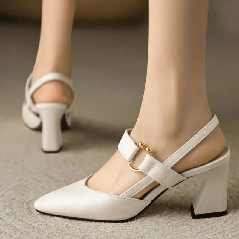 Black slingback block heels with curved sculptural heel, gold accent, and elegant pointed toe