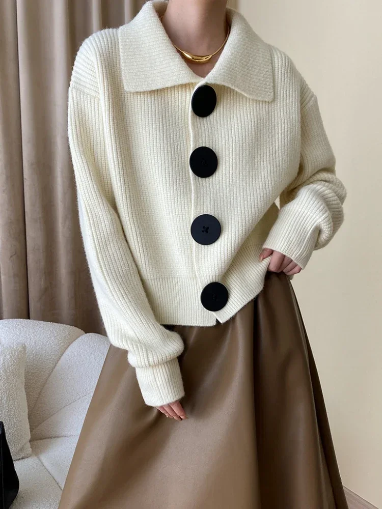 Women's oversized knit cardigan in neutral tones with bold black statement buttons, relaxed fit
