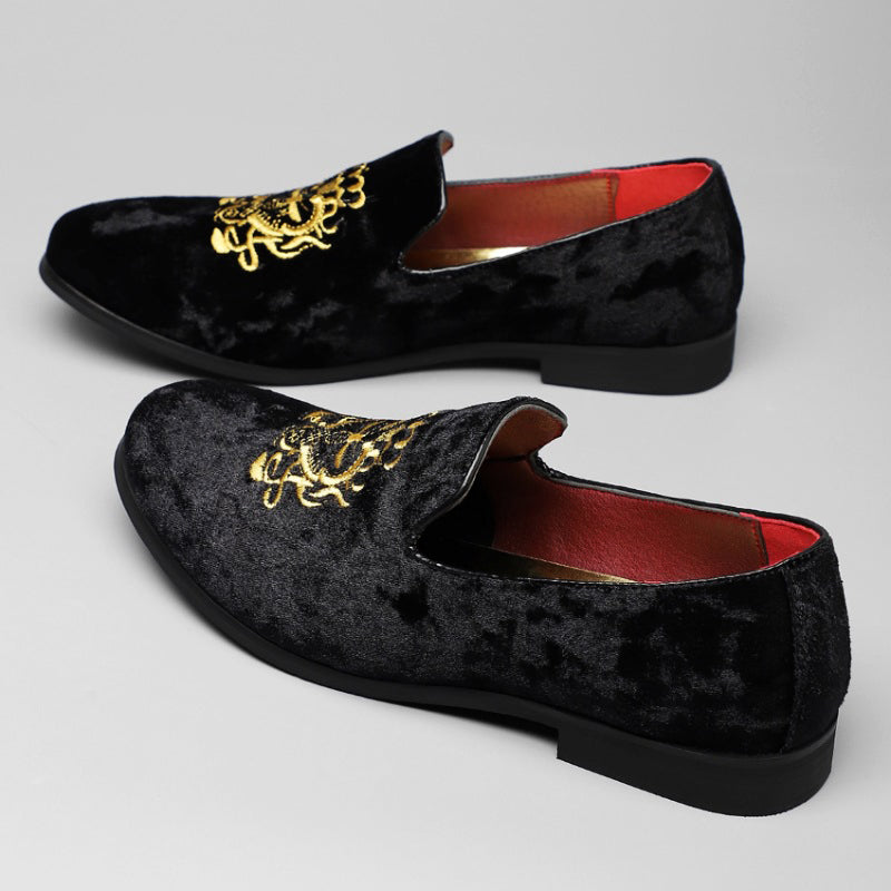 Burgundy velvet loafers with golden crest emblem and bold red interior lining for luxury style