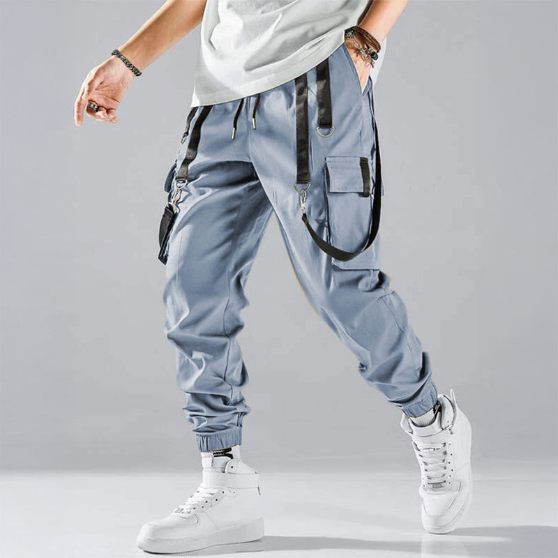 Black cargo trousers with tactical pockets, harness details, and adjustable buckle straps for streetwear
