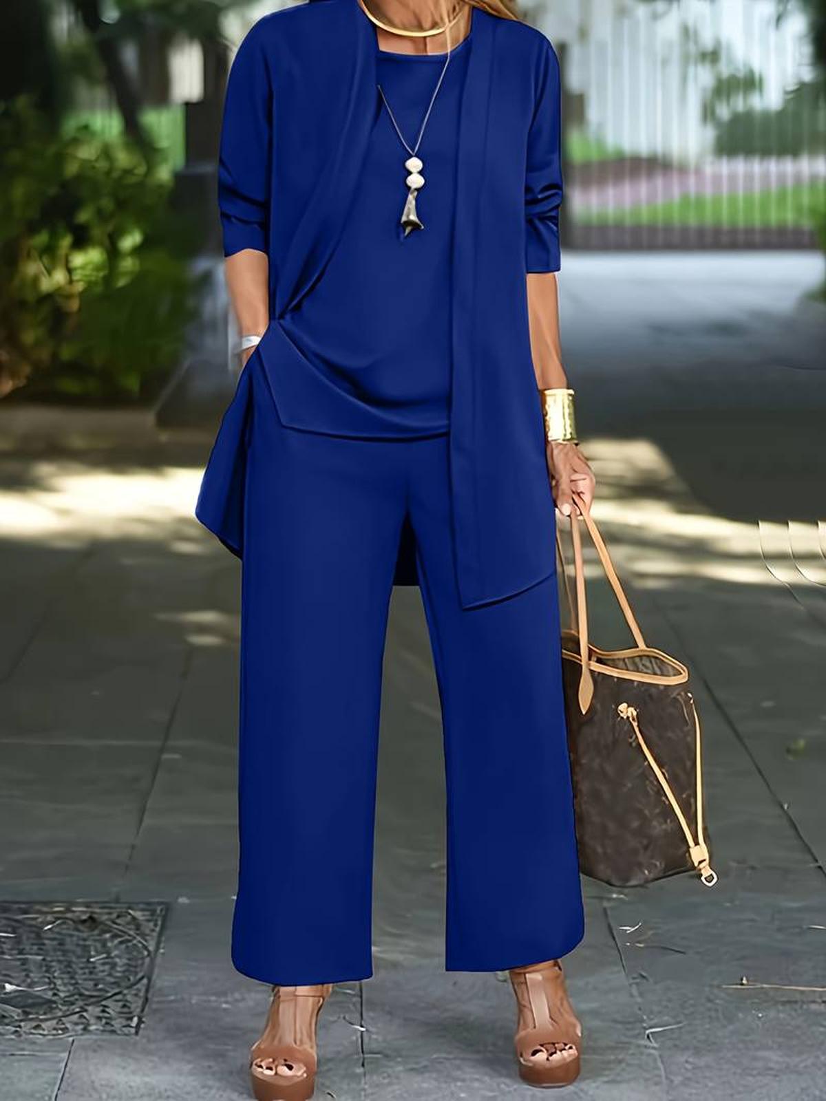 Women's three-piece relaxed outfit set in neutral tones with flowing top, wide-leg pants, and lightweight layer