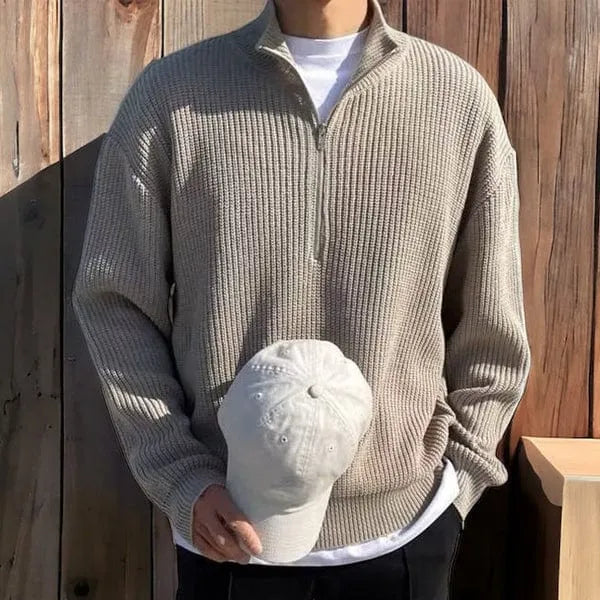 Men's grey half-zip sweater with high collar, classic rib-knit texture, and refined minimalist silhouette