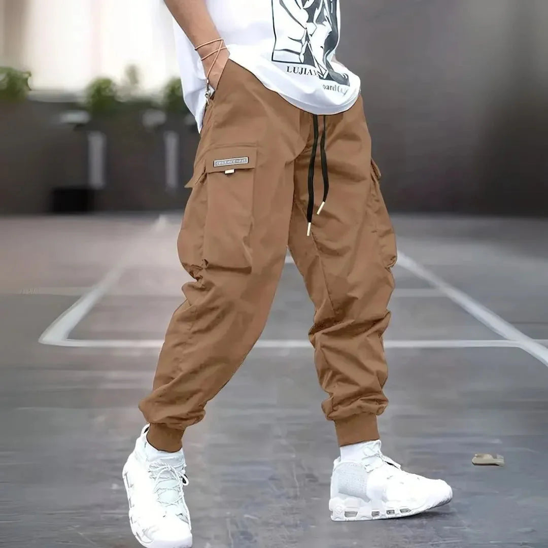 Men's olive cargo jogger pants with ribbed cuffs, adjustable drawstring waist, and multi-pocket utility design