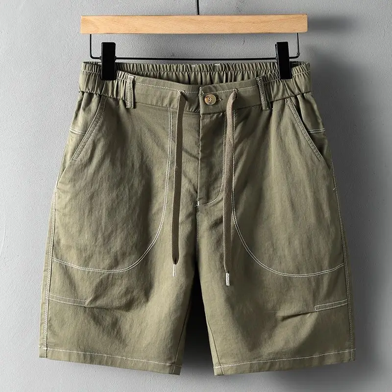 Men's khaki streetwear utility shorts with oversized contrast-stitched pockets and elastic drawstring waist