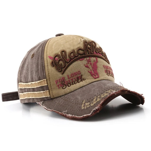 Black trucker hat with distressed details, embroidered Rebel logo, adjustable snapback, edgy streetwear style