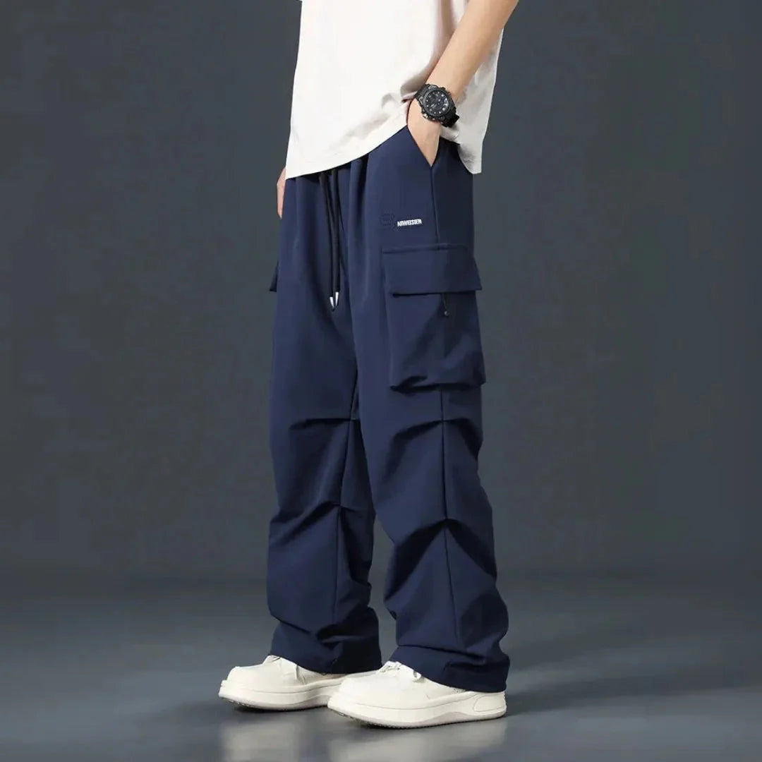 Men's black oversized cargo pants with multi-pocket streetwear design and adjustable drawstring waist