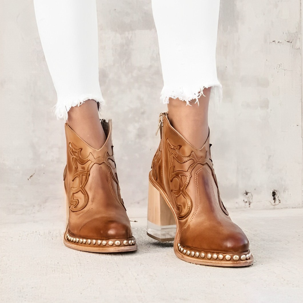 Women's black Western block heel boots with metallic studs, intricate stitching, and transparent clear heel