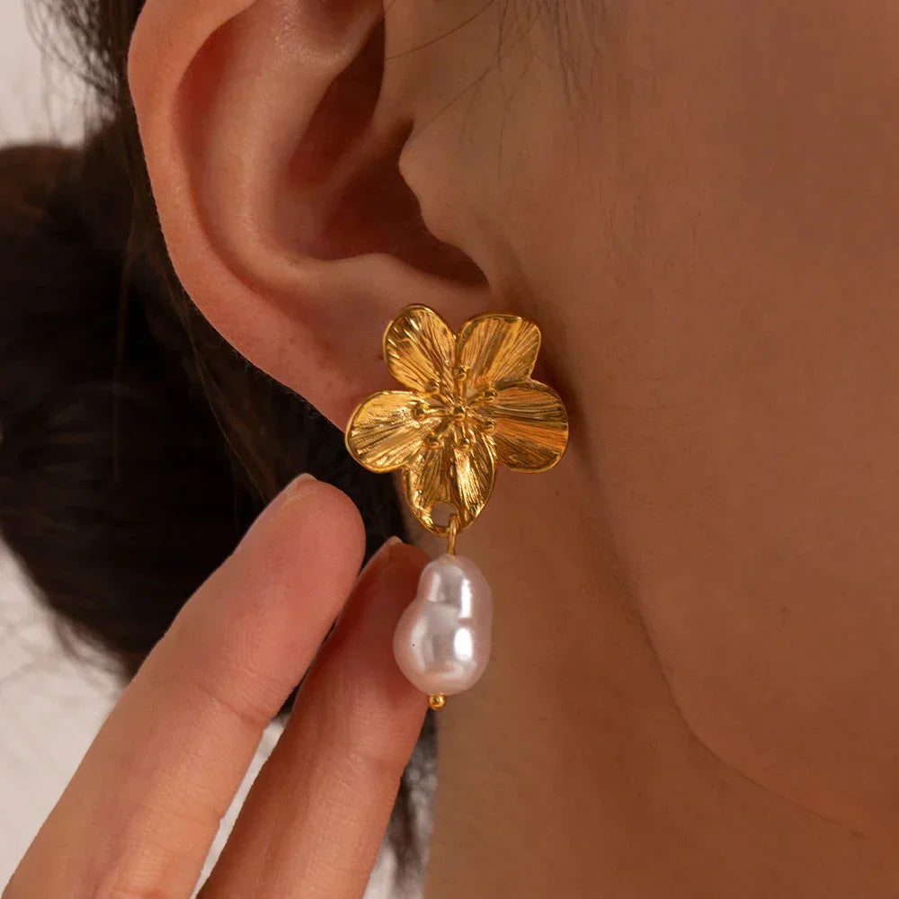 Oversized gold-tone floral stud earrings with bold five-petal design and textured veining finish