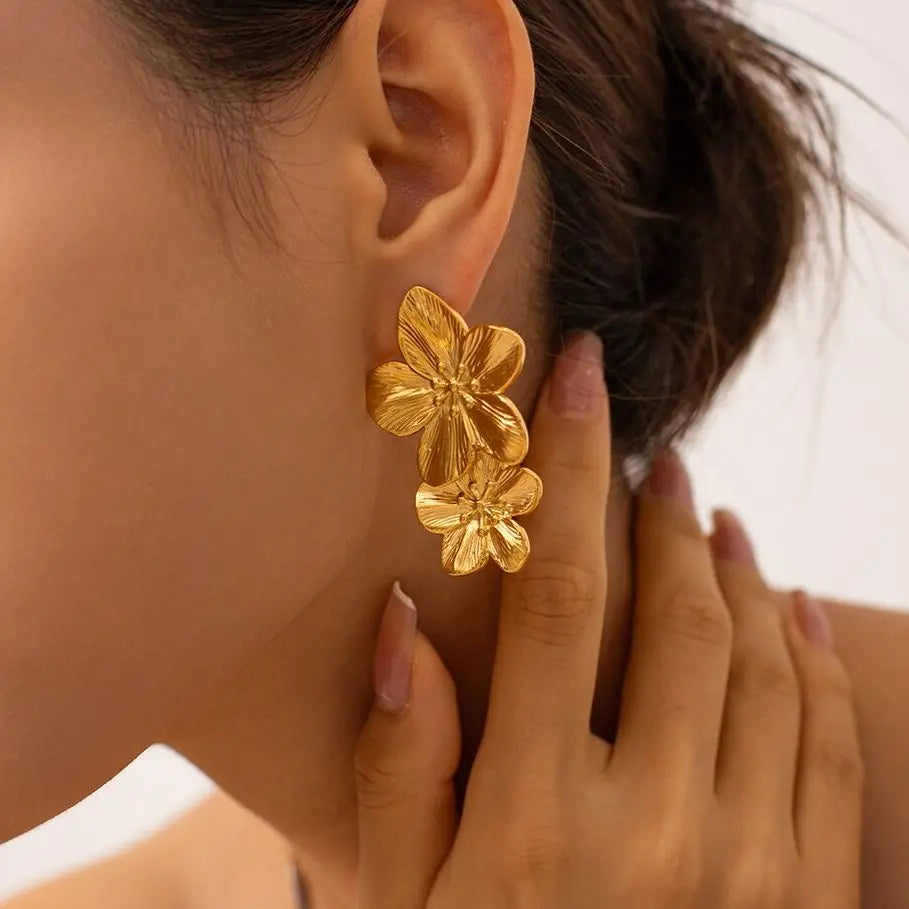 Women's oversized gold-tone floral statement earrings with bold five-petal bloom and textured veining