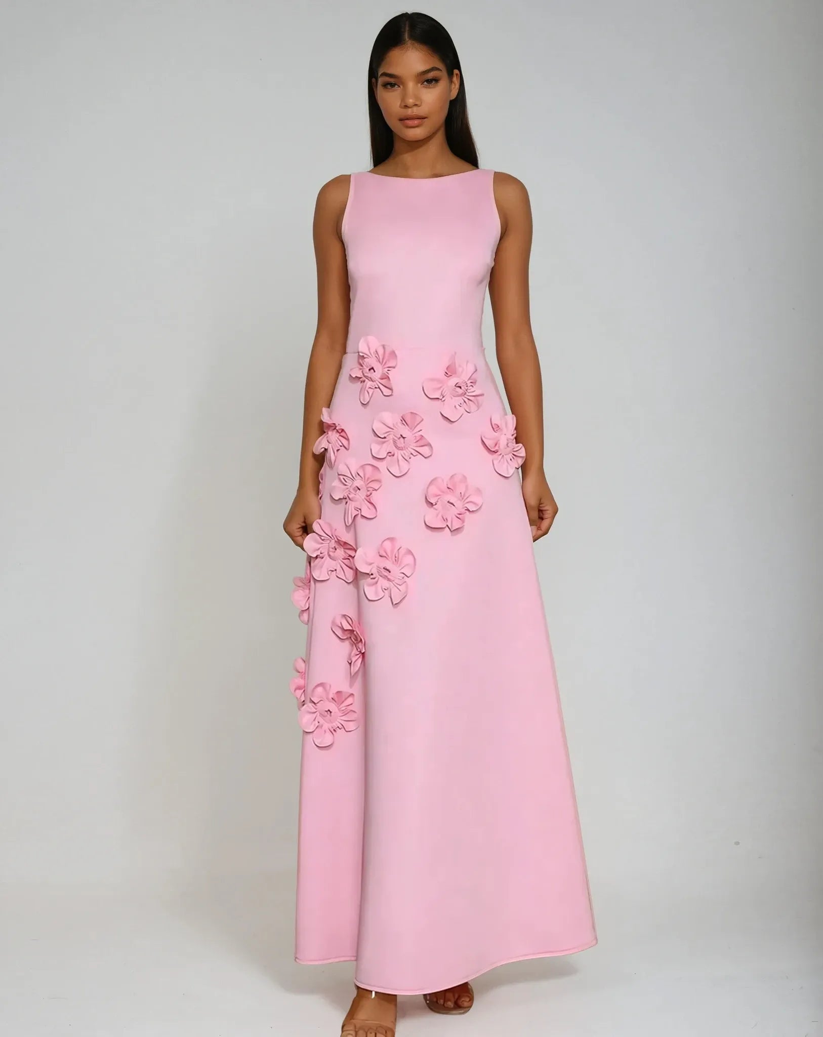 Ivory sleeveless maxi gown with sculpted floral appliqué cascading skirt, elegant bridal silhouette