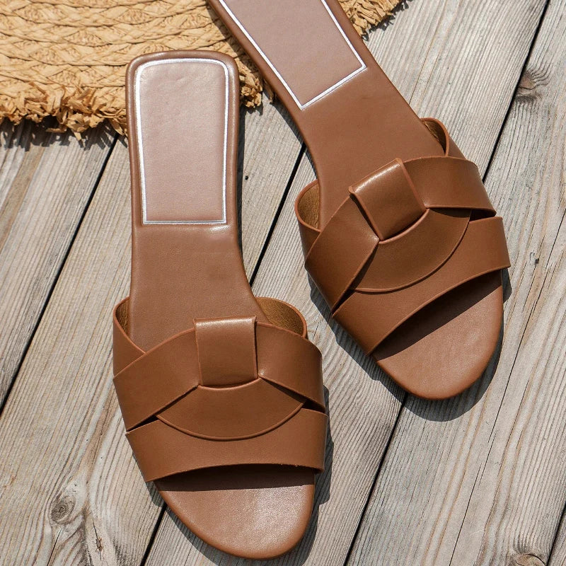 Women's flat PU leather slip-on slippers in sleek silhouette, polished finish for summer casual style