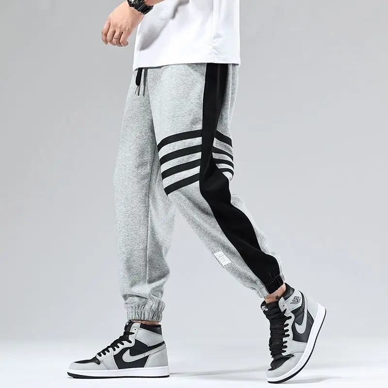 Dual-tone color block varsity joggers with elastic cuffs, bold contrast paneling and athletic stripe detail