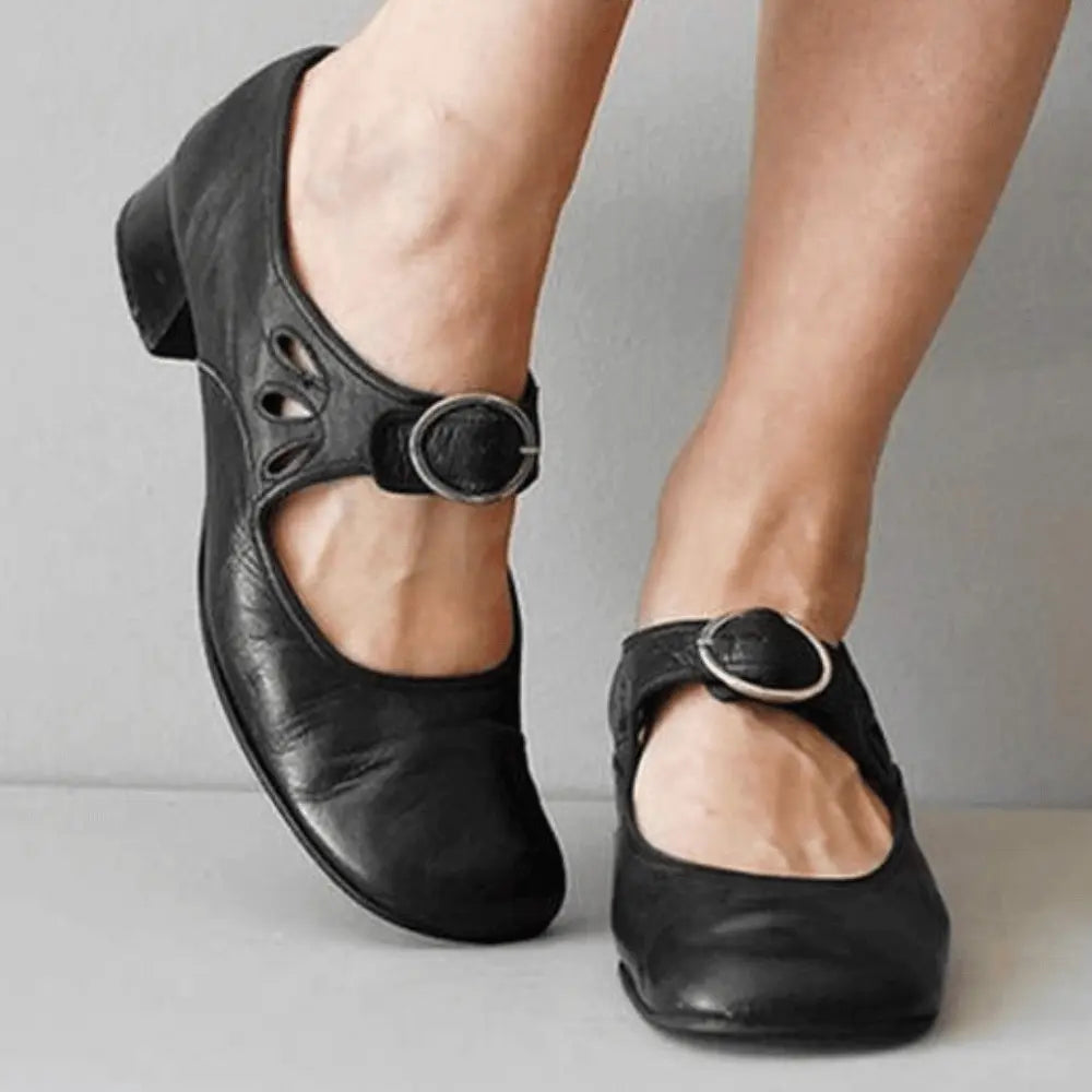 Women's black vintage Mary Jane flats with adjustable buckle strap and delicate cutout detailing