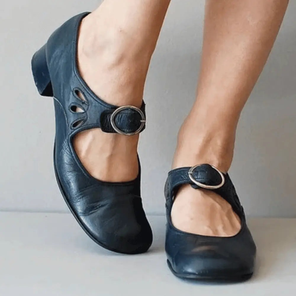 Women's black vintage Mary Jane flats with adjustable buckle strap and delicate cutout detailing
