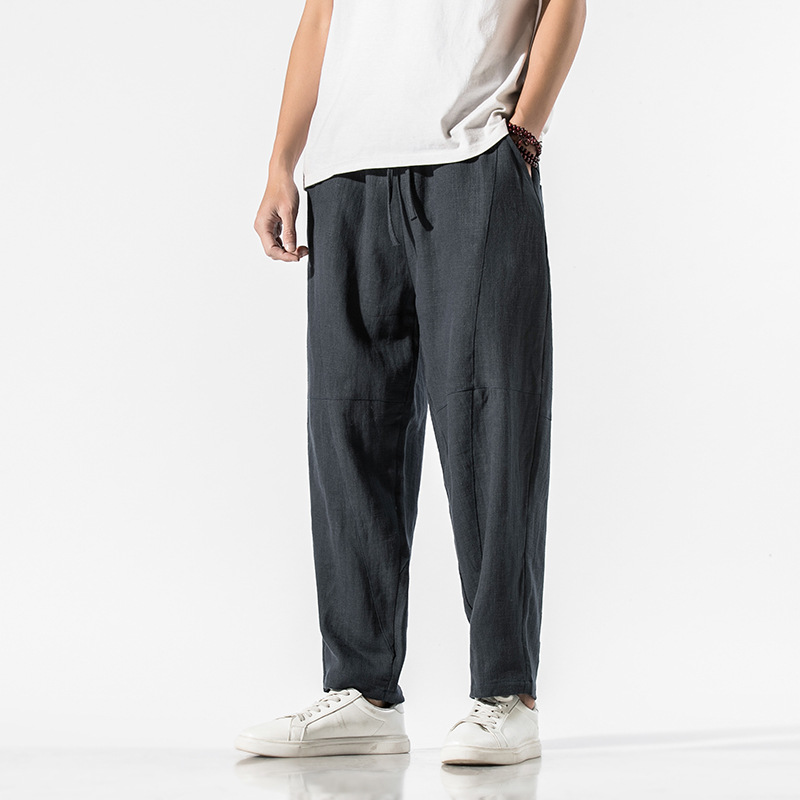 Beige linen blend relaxed tapered pants with articulated seam panels and adjustable waist