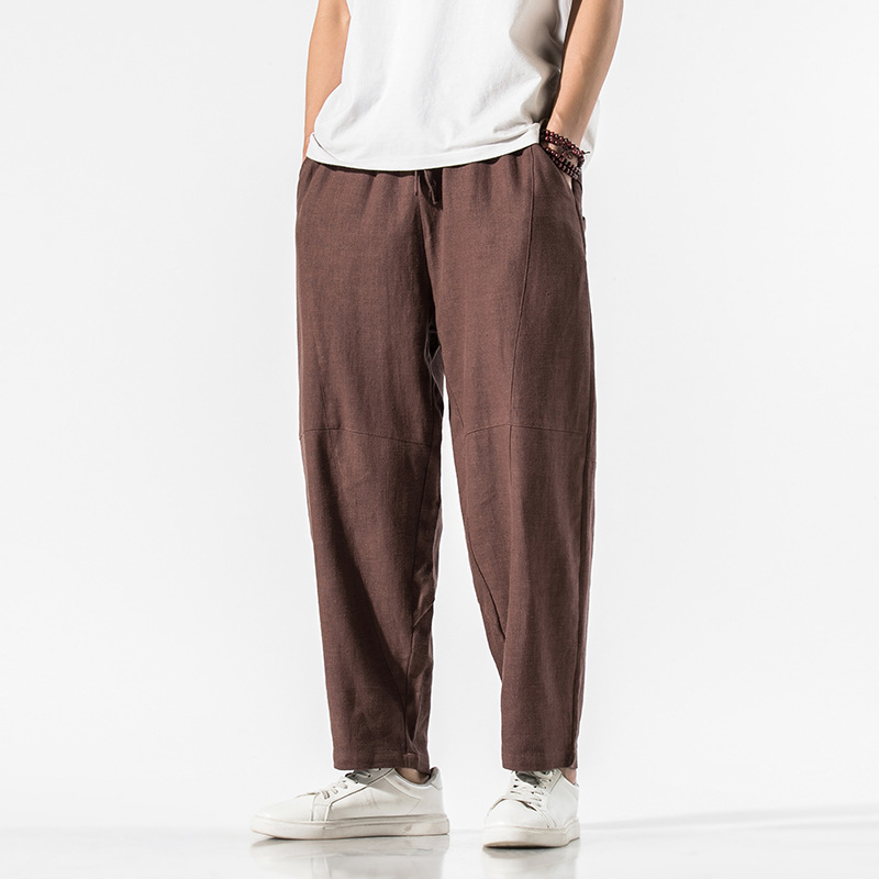 Beige linen blend relaxed tapered pants with articulated seam panels and adjustable waist