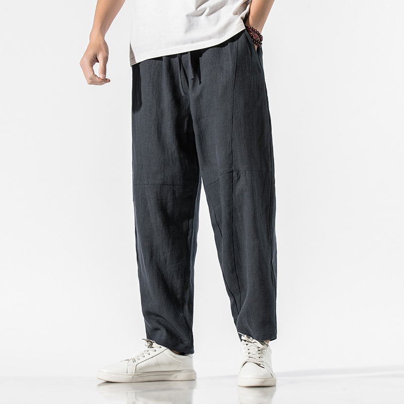 Beige linen blend relaxed tapered pants with articulated seam panels and adjustable waist