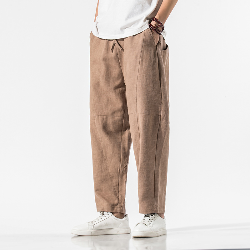 Beige linen blend relaxed tapered pants with articulated seam panels and adjustable waist