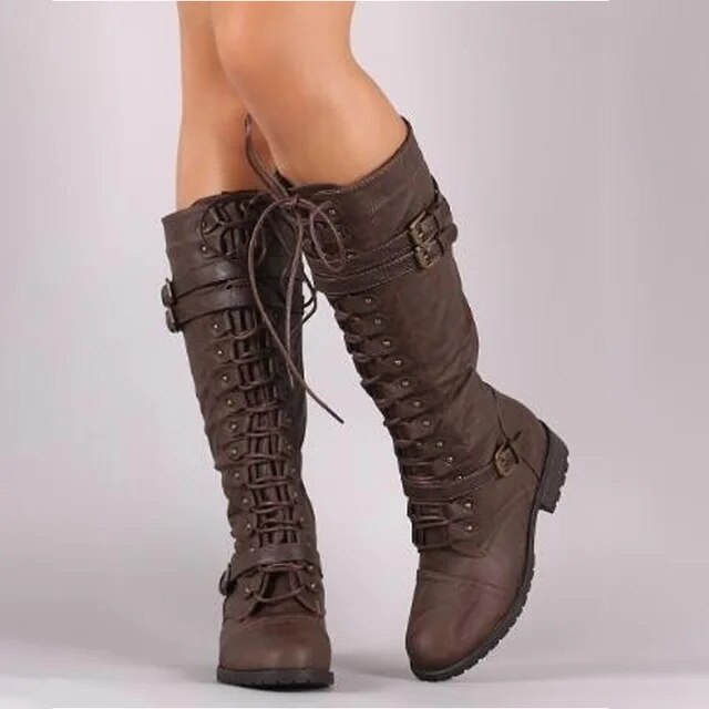 Women's brown leather knee-high boots with lace-up front, buckle detail, and rugged sole structured fit