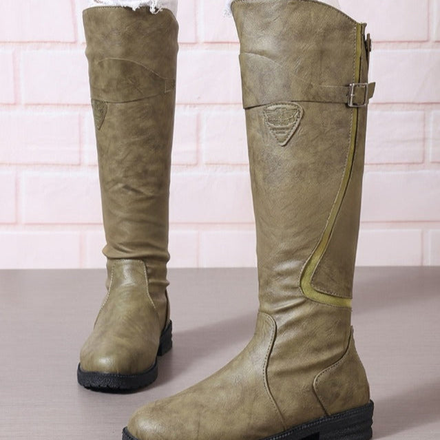 Women's tall riding boots in classic silhouette with subtle contour stitching and decorative buckle accents