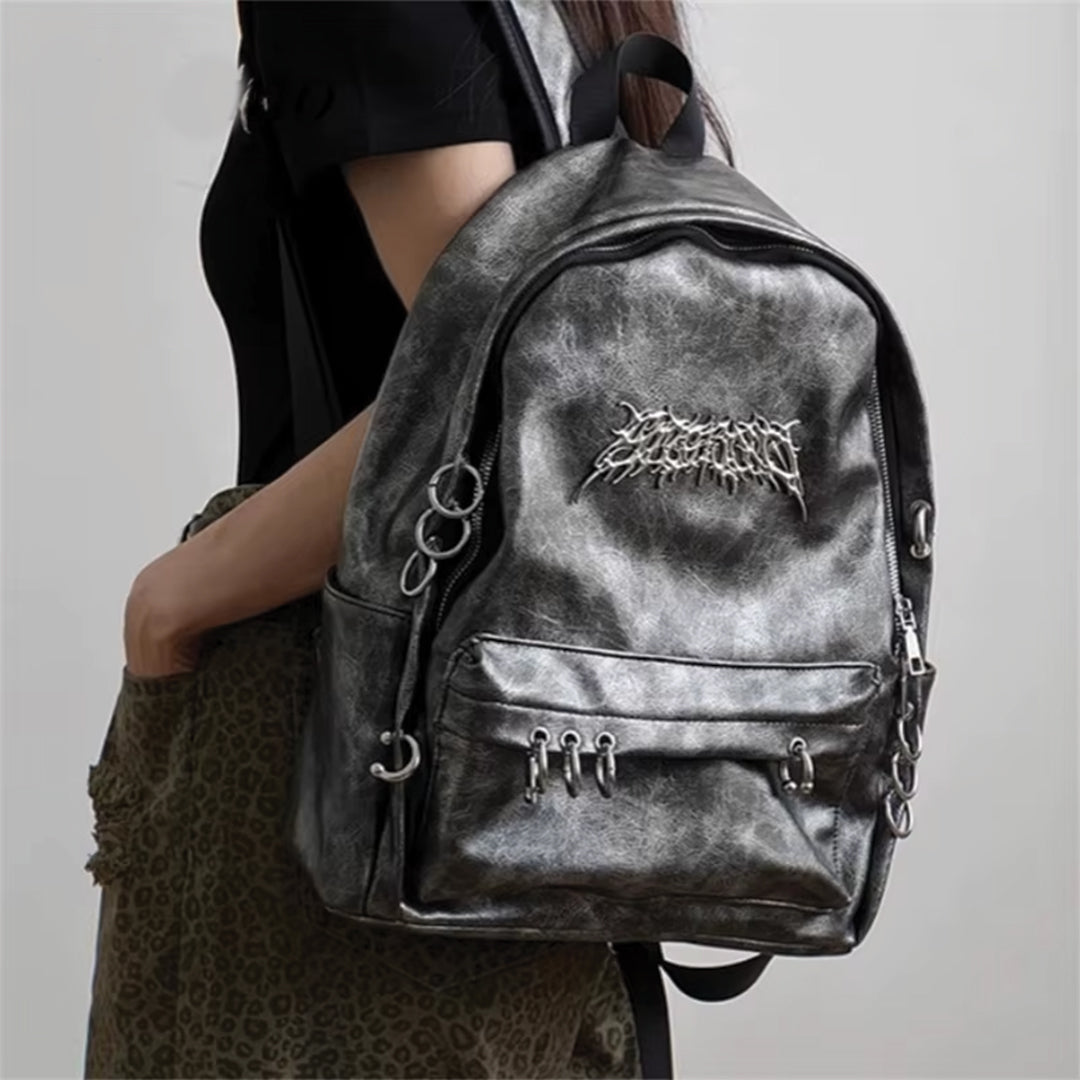 Rebel Chrome vegan leather punk backpack with metallic circles, secure zippers, and spacious front pouch