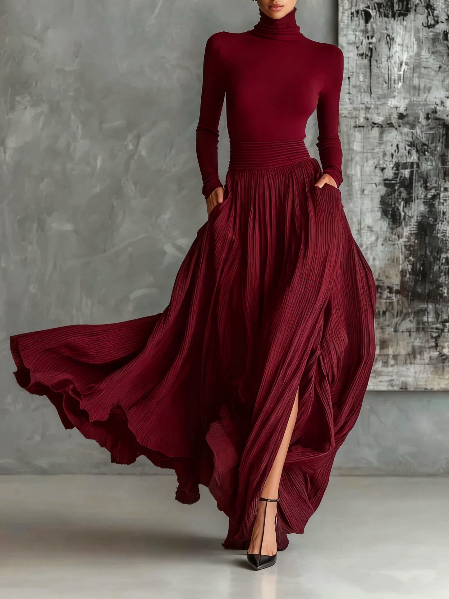 Elegant pleated maxi gown with high neck, long sleeves, flowing skirt and side slit for formal evenings