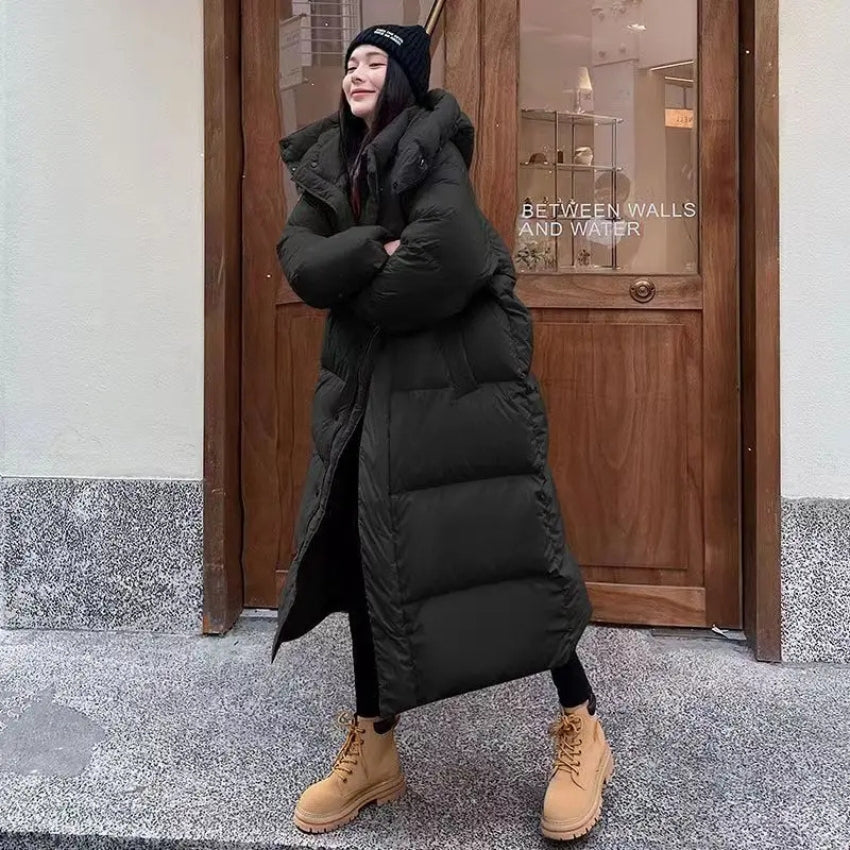 Women's long oversized down jacket with hood, cozy elegant winter style in neutral tone
